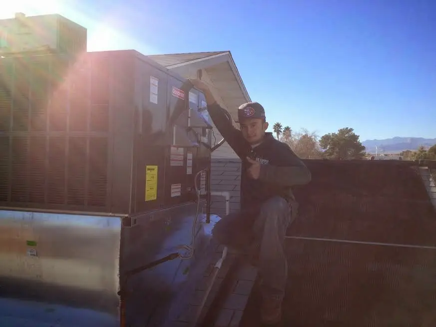 HVAC technician performing Heat Pump Repair on a rooftop unit in Woods Creek